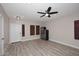Open-concept living room featuring wood-look flooring, a white door, and a ceiling fan at 537 S 153Rd Ln, Goodyear, AZ 85338