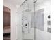 Modern shower featuring a rainfall shower head, and sleek glass enclosure with marble-patterned tile surround at 537 S 153Rd Ln, Goodyear, AZ 85338