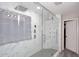Large shower features dual shower heads, a glass enclosure, marble-patterned tile surround and shower seat at 537 S 153Rd Ln, Goodyear, AZ 85338