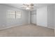 A cozy bedroom featuring plush carpeting, a ceiling fan, and a spacious closet, providing comfort and storage at 5436 E Aspen E Ave, Mesa, AZ 85206