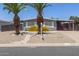 Charming single-story home featuring desert landscaping and mature palm trees, creating inviting curb appeal at 5436 E Aspen E Ave, Mesa, AZ 85206