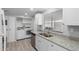 Updated kitchen with stainless steel appliances, stylish countertops, and adjacent laundry area for added convenience at 5436 E Aspen E Ave, Mesa, AZ 85206