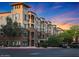Beautiful exterior shot of building with stone accents, balconies, and well-maintained landscaping at sunset at 5450 E Deer Valley Dr # 2191, Phoenix, AZ 85054