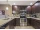 Close-up of modern kitchen featuring stainless steel appliances, tile backsplash, and dark wood cabinets at 5450 E Deer Valley Dr # 2191, Phoenix, AZ 85054
