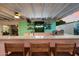 View of the outdoor kitchen with granite countertop, stainless steel grill, bar seating, and decorative neon signage at 5707 N 12Th Pl, Phoenix, AZ 85014