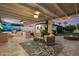 Relaxing covered patio with outdoor kitchen, seating, fire pit, and artistic wall decor at 5707 N 12Th Pl, Phoenix, AZ 85014