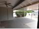 Covered back patio with concrete floors, brick pillars, ceiling fan, and greenery at 5720 E University Dr, Mesa, AZ 85205