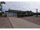 Attractive single-story home showcasing desert landscaping and a concrete driveway leading to a garage at 5720 E University Dr, Mesa, AZ 85205