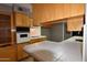 Well-lit kitchen with tile countertops and light wood cabinetry at 5720 E University Dr, Mesa, AZ 85205