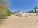A view of the backyard featuring a block fence and chain-link fence with desert landscaping and mature trees at 5905 E Donna Ln, Paradise Valley, AZ 85253