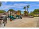 Expansive backyard featuring a patio with seating, BBQ grill, lush landscaping, and palm trees at 6546 E Dallas St, Mesa, AZ 85205