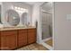 Bathroom featuring a double vanity, wood cabinets, and a glass-enclosed shower at 6546 E Dallas St, Mesa, AZ 85205