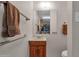 Classic bathroom featuring a wood vanity, a framed mirror, and towel bars at 6546 E Dallas St, Mesa, AZ 85205