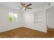 Bright bedroom with wood floors, ceiling fan, a window and built-in shelving at 6546 E Dallas St, Mesa, AZ 85205