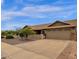 Side view of a single-story home with a brown roof, two-car garage, and well maintained front yard at 6546 E Dallas St, Mesa, AZ 85205