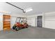 Spacious garage with ample storage, including an orange golf cart and white refrigerator at 6546 E Dallas St, Mesa, AZ 85205