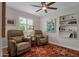 Cozy living room featuring two recliner chairs, a bright window, and built-in shelving at 6546 E Dallas St, Mesa, AZ 85205