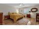 Comfortable bedroom with a floral bedspread, a ceiling fan, and natural light from the window at 6546 E Dallas St, Mesa, AZ 85205