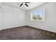 Bright bedroom with neutral carpet, ceiling fan, and natural light from the window at 6938 W Nicolet Ave, Glendale, AZ 85303