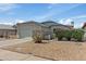 Inviting single-story home with a two-car garage, xeriscaping, and lush green bushes at 6938 W Nicolet Ave, Glendale, AZ 85303