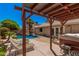 Relaxing backyard featuring a pool, hot tub, pergola, and outdoor seating, ideal for entertaining guests at 7426 W Cholla St, Peoria, AZ 85345