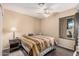 Bedroom with wood-look floors, ceiling fan, window, and bedside table with lamp at 7426 W Cholla St, Peoria, AZ 85345