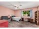 Bedroom with wood-look floors, ceiling fan, desk beneath window, and sitting chair at 7426 W Cholla St, Peoria, AZ 85345