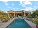 Stunning backyard featuring a large pool, lush desert landscaping, and covered patio at 7846 E Wilderness Trl, Gold Canyon, AZ 85118