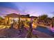 Sprawling backyard oasis with pool, desert landscaping, and multiple seating areas at dusk at 7846 E Wilderness Trl, Gold Canyon, AZ 85118