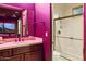 Bathroom featuring pink walls, dark wood vanity, and a glass-enclosed shower with tiled walls at 7846 E Wilderness Trl, Gold Canyon, AZ 85118