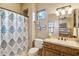 Cozy bathroom features a vanity with a wooden cabinet, a patterned shower curtain, and bright, natural light at 7846 E Wilderness Trl, Gold Canyon, AZ 85118