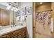 Bathroom featuring wooden vanity and framed artwork, adjacent to a shower with patterned curtain at 7846 E Wilderness Trl, Gold Canyon, AZ 85118