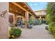 Inviting covered courtyard with a seating area, desert decor, colorful plantings, and a calming desert atmosphere at 7846 E Wilderness Trl, Gold Canyon, AZ 85118