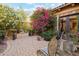 Charming desert courtyard featuring mature landscaping, lush foliage, seating area, desert views, and shade at 7846 E Wilderness Trl, Gold Canyon, AZ 85118
