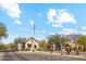 Picturesque stone entry gatehouse, flag, and surrounding desert landscape at 7846 E Wilderness Trl, Gold Canyon, AZ 85118