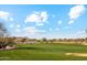 Lush green golf course with blue sky and a few players in the distance at 7846 E Wilderness Trl, Gold Canyon, AZ 85118