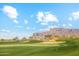 Lush green golf course with scenic mountain views and blue skies at 7846 E Wilderness Trl, Gold Canyon, AZ 85118