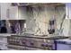 Gourmet kitchen featuring a stainless steel range, modern backsplash, and custom cabinetry at 7846 E Wilderness Trl, Gold Canyon, AZ 85118