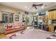 Cozy living room with a comfortable pink sofa, glass desk, and views of the landscaped backyard at 7846 E Wilderness Trl, Gold Canyon, AZ 85118