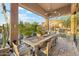 Charming outdoor dining area with rustic table, built-in grill, and views of the lush desert landscape at 7846 E Wilderness Trl, Gold Canyon, AZ 85118