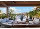 Inviting covered patio with plush seating overlooks a sparkling pool and mountain views, perfect for outdoor living at 7846 E Wilderness Trl, Gold Canyon, AZ 85118
