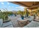 Expansive covered patio featuring comfortable seating, outdoor kitchen, and serene views of the private pool at 7846 E Wilderness Trl, Gold Canyon, AZ 85118