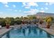 Tranquil pool area with mature landscaping, cascading waterfalls, and desert mountain views, perfect for relaxing at 7846 E Wilderness Trl, Gold Canyon, AZ 85118
