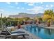 Lounge by the refreshing pool with water features and desert mountain views, perfect for relaxation at 7846 E Wilderness Trl, Gold Canyon, AZ 85118