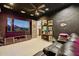 Modern home theater features comfy seating, black accent wall, neon lighting, and a large television at 7846 E Wilderness Trl, Gold Canyon, AZ 85118