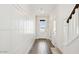 Bright hallway with wood-look tile flooring, white wainscoting and neutral walls at 8030 W Griswold Rd, Peoria, AZ 85345