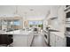 Open-concept kitchen with sleek white cabinetry, quartz countertops, and stainless-steel appliances at 8030 W Griswold Rd, Peoria, AZ 85345