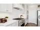Close up of a kitchen with quartz countertops, stainless steel appliances, and sleek white cabinets at 8030 W Griswold Rd, Peoria, AZ 85345