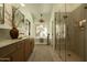 A bright bathroom with a walk-in shower, dual vanity, and a garden view from the tub at 8910 E Topeka Dr, Scottsdale, AZ 85255