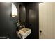 Modern bathroom featuring stone sink, unique mirror, and stylish lighting at 8910 E Topeka Dr, Scottsdale, AZ 85255